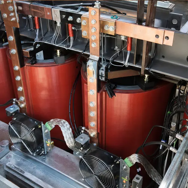Detail view of busbar terminations and cooling fans on the windings of a cast-resin dry-type transformer