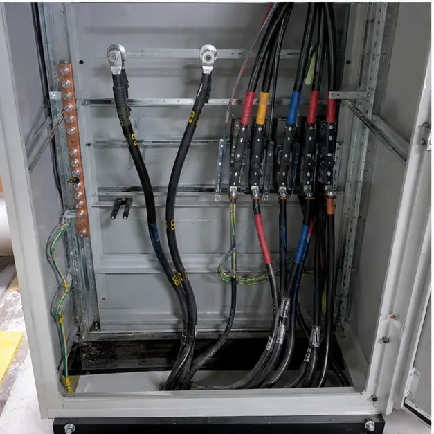 Close view of medium-voltage cable terminations and earth bonding inside the rear compartment of a switchgear panel